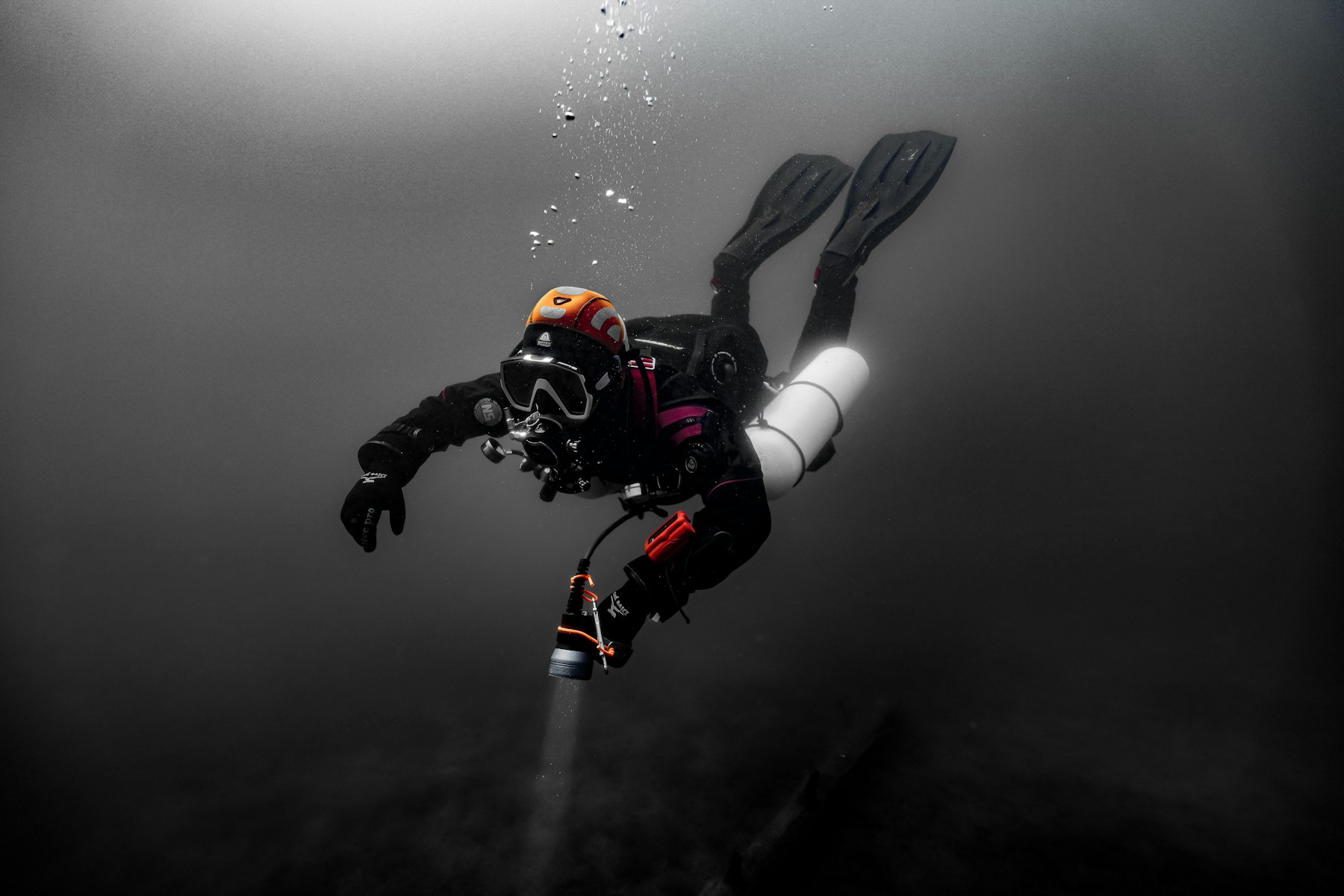 A diver descending into dark open water