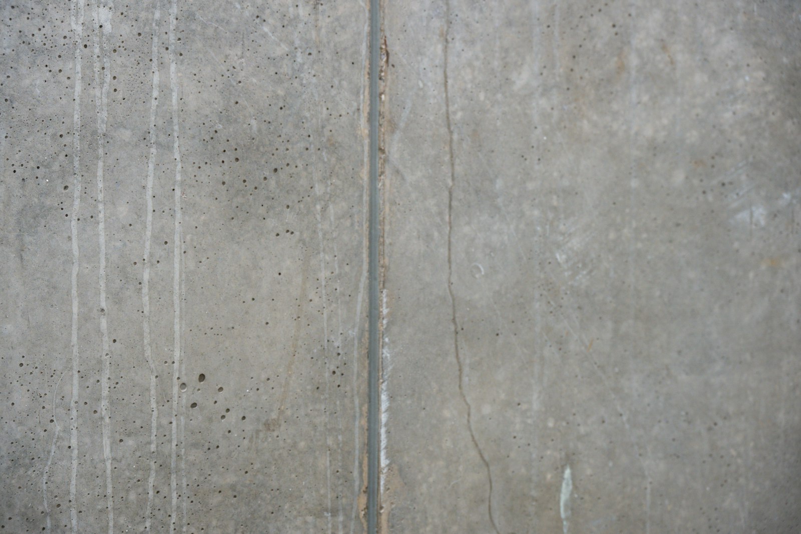 Board-marked concrete wall with vertical streaks, cast by the fictional Formwork crew