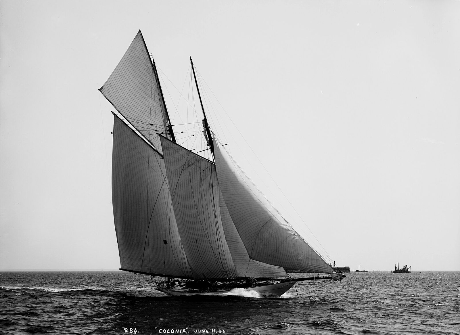 A schooner running hard before the wind, white bow wave, black and white photograph